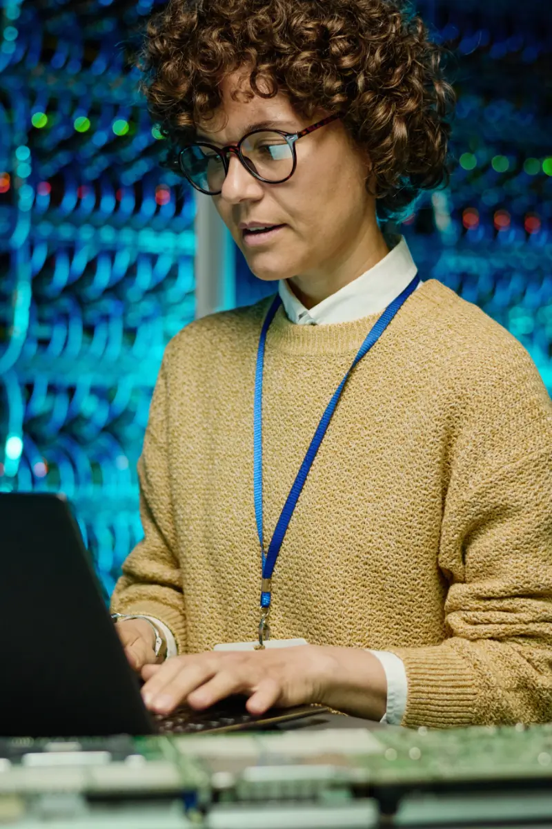 Engineer woman working with laptop in data center