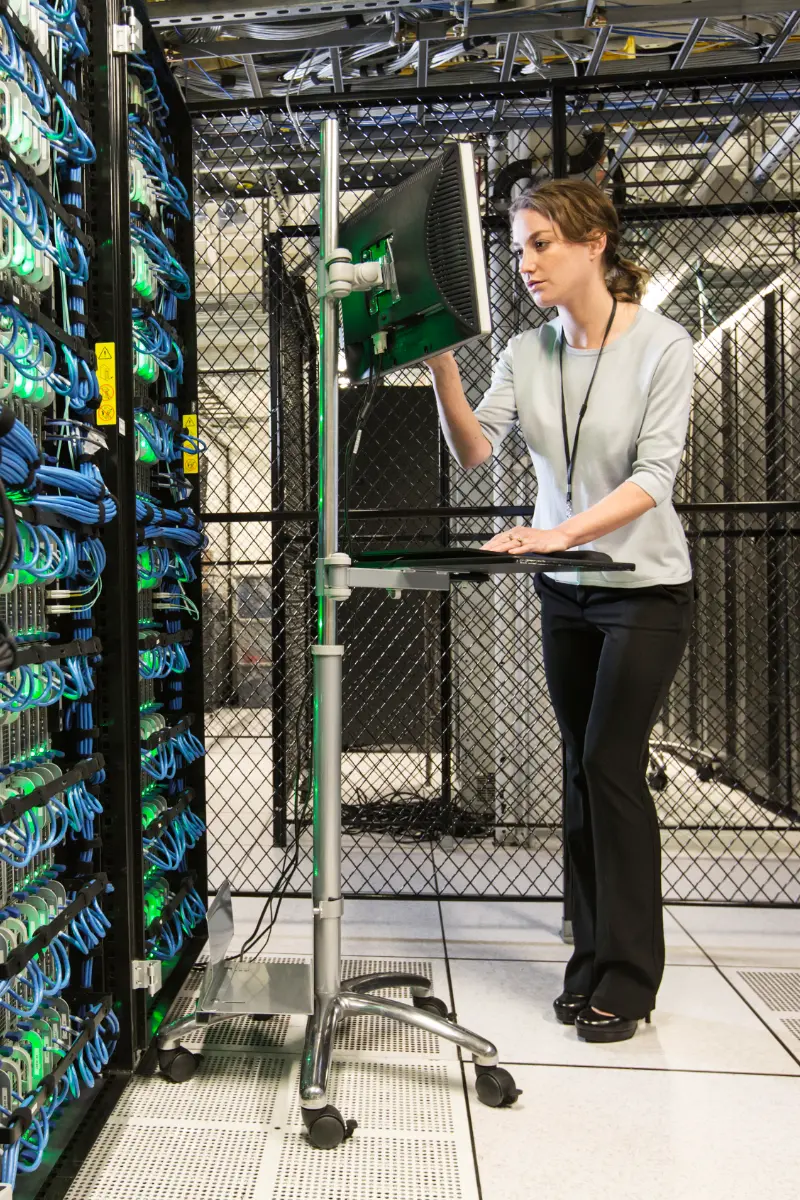 Woman technician doing diagnostic tests on computer servers in a server farm.